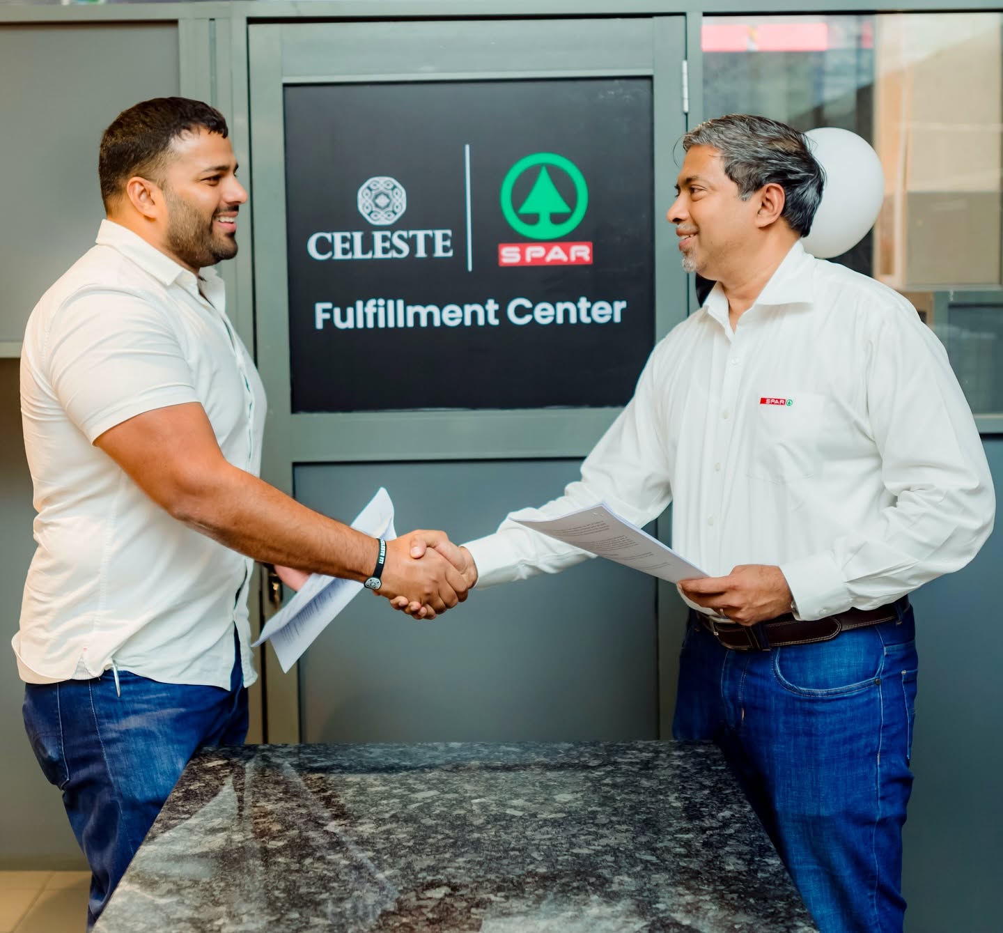Two business representatives shaking hands at a fulfillment center