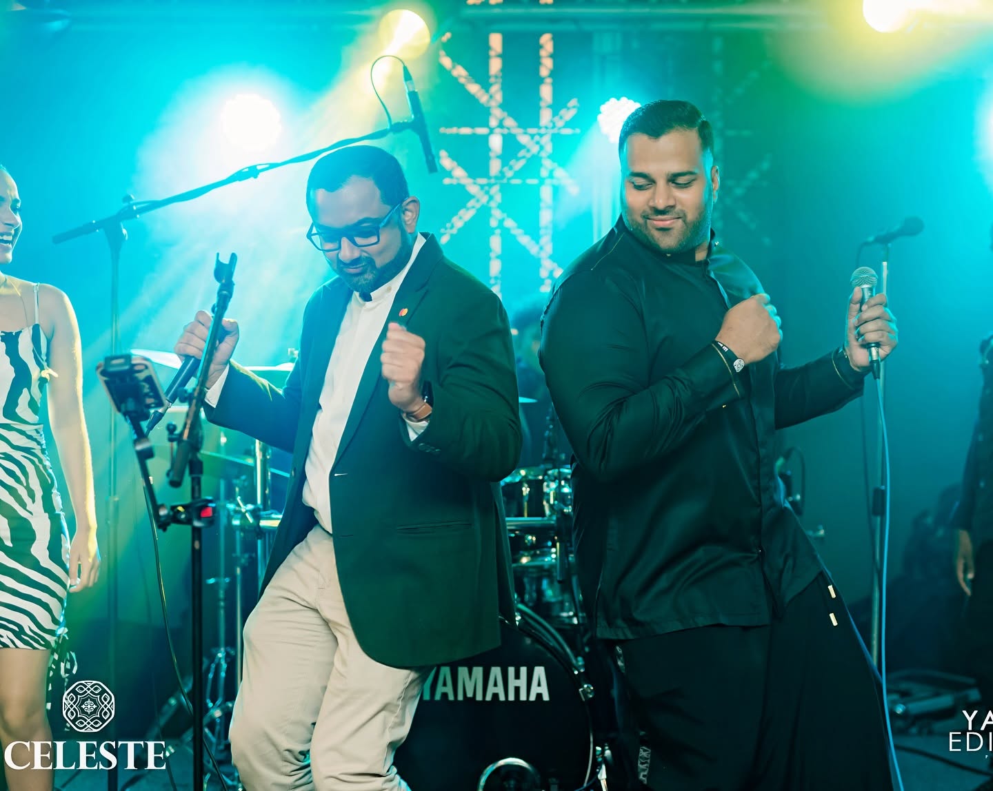 Two performers singing together on a concert stage