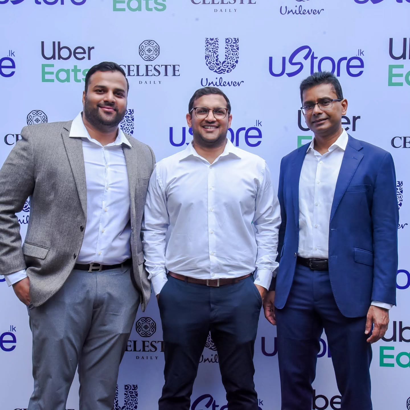 Three business partners standing together at a branded event