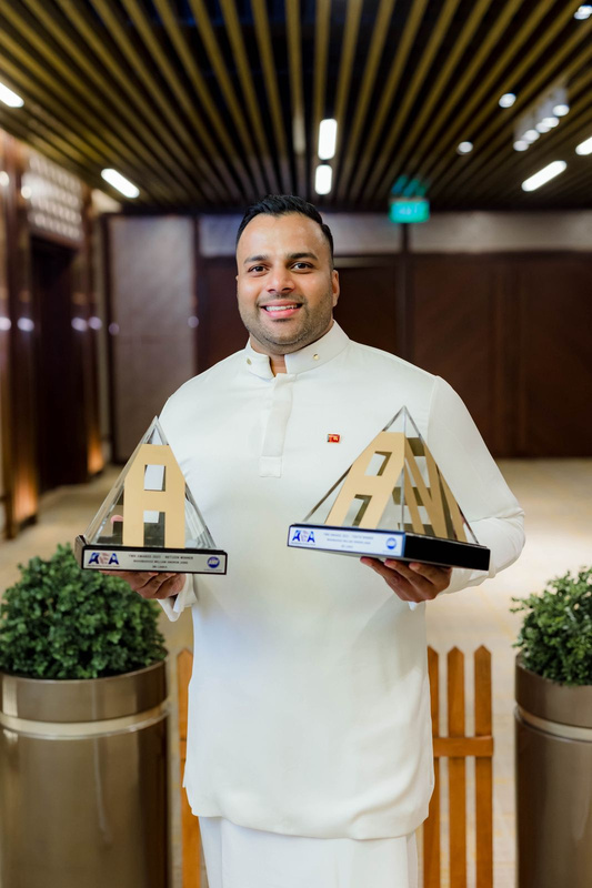 Janik Jayasuriya holding two awards